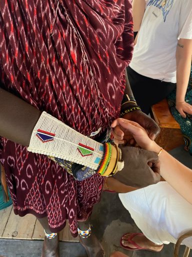 Bunte Armbänder und Hände verschiedener Personen, die sich festhalten.